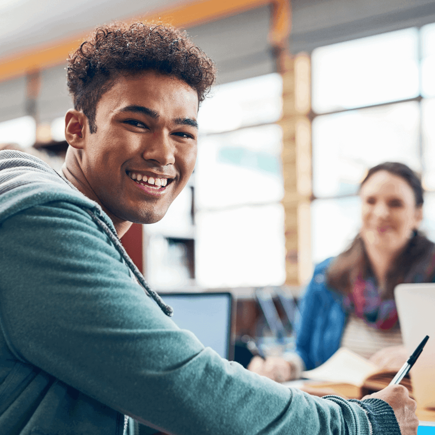 Smiling person sitting at a desk looking at the camera