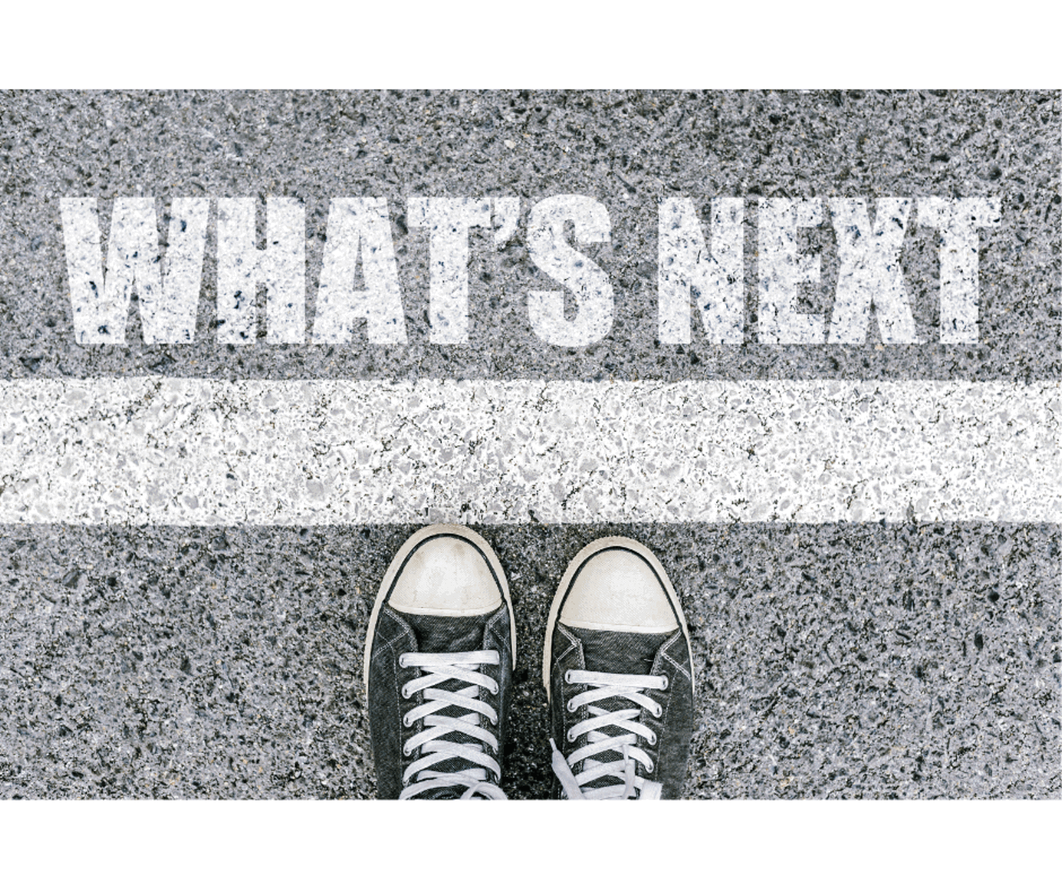 Pair of shoes on a road with 'What's next' painted on the road